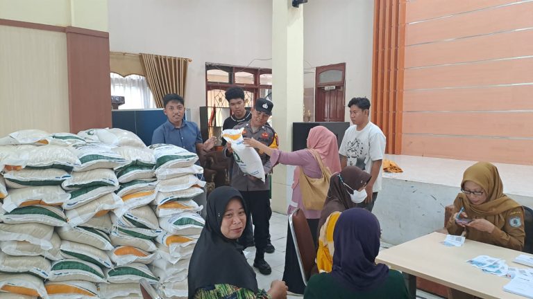 Bhabinkamtibmas Loktuan Pastikan Keamanan Penyaluran Bantuan Pangan Beras Bulog